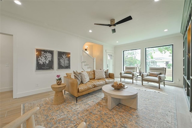 living room featuring crown molding, ceiling fan, and light hardwood / wood-style floors