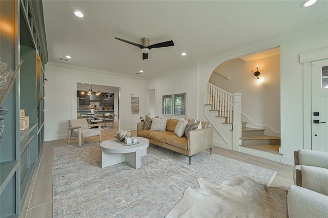 living room featuring ceiling fan, hardwood / wood-style flooring, and ornamental molding