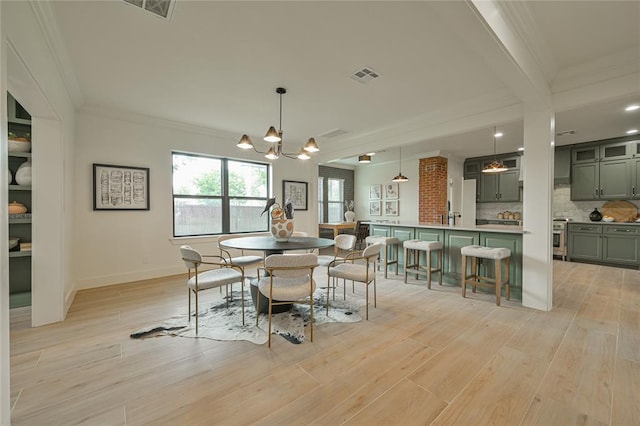 dining area featuring light hardwood / wood-style flooring, beamed ceiling, a chandelier, and ornamental molding