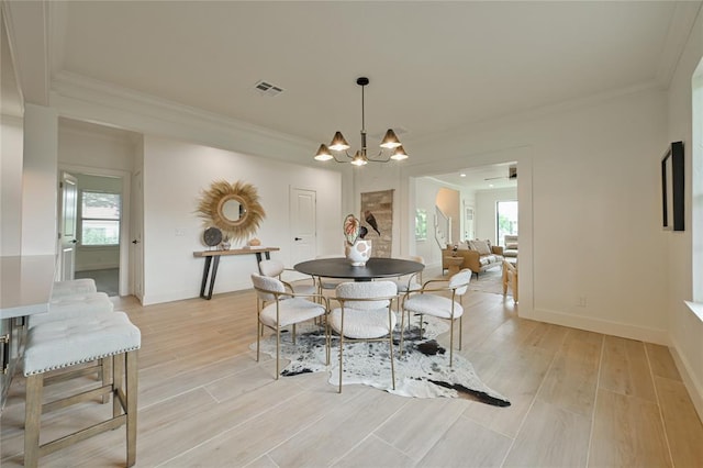 dining room featuring a chandelier, plenty of natural light, and crown molding