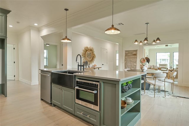 kitchen with sink, stainless steel appliances, light hardwood / wood-style flooring, an island with sink, and decorative light fixtures