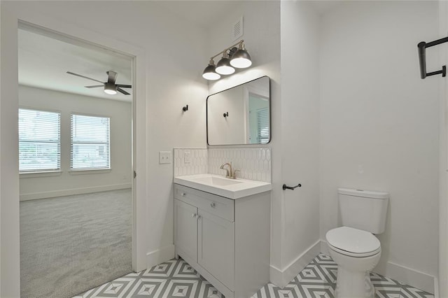 bathroom with vanity, decorative backsplash, ceiling fan, and toilet