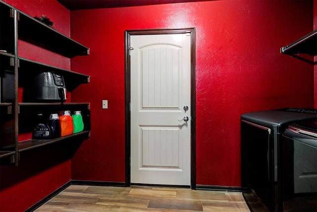 laundry room with hardwood / wood-style floors and washing machine and clothes dryer