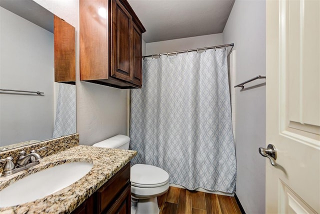 bathroom with toilet, wood-type flooring, and vanity