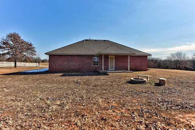 rear view of property with an outdoor fire pit