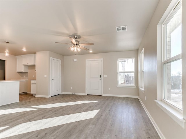 unfurnished living room with ceiling fan and light hardwood / wood-style floors