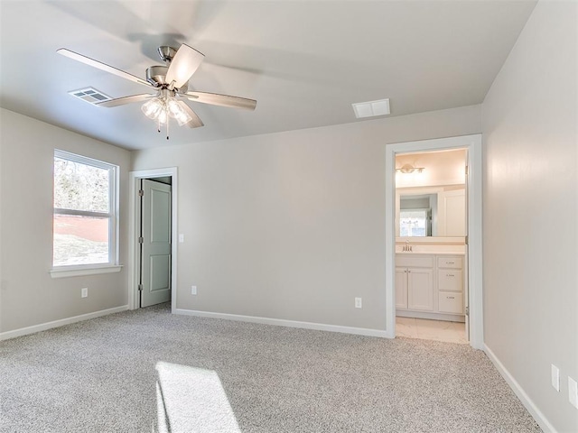 unfurnished bedroom with ceiling fan, ensuite bathroom, and light carpet