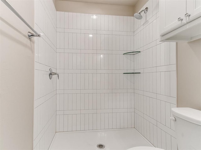 bathroom featuring toilet and tiled shower