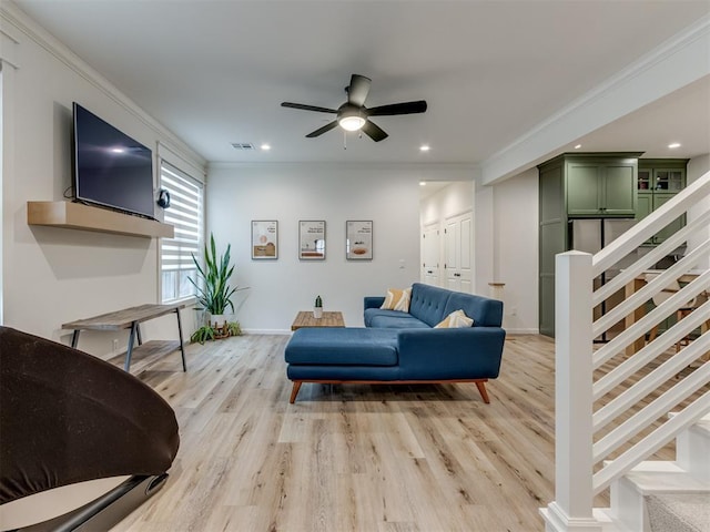 living room with ceiling fan, ornamental molding, and light hardwood / wood-style flooring