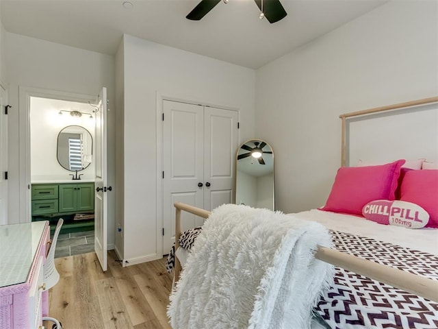 bedroom with ceiling fan, ensuite bath, sink, light hardwood / wood-style flooring, and a closet