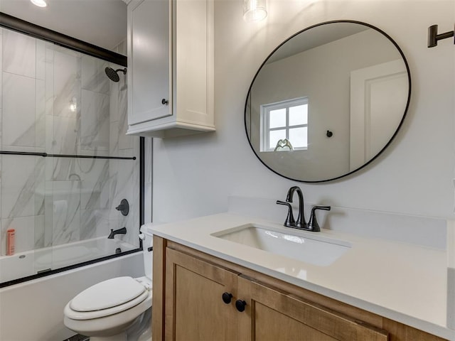 full bathroom with combined bath / shower with glass door, vanity, and toilet