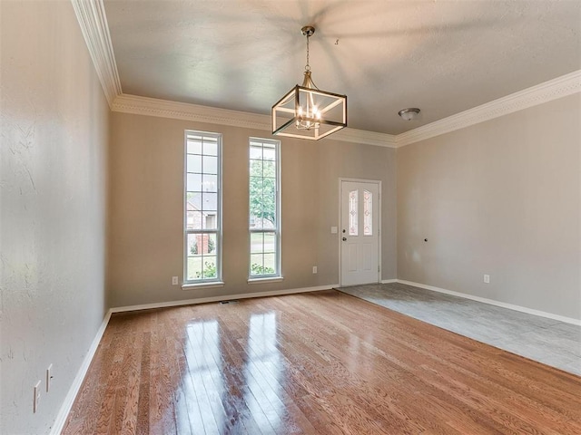 interior space with an inviting chandelier, hardwood / wood-style floors, and crown molding