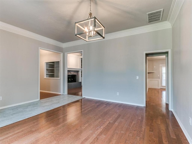 unfurnished room featuring crown molding, a fireplace, and hardwood / wood-style floors