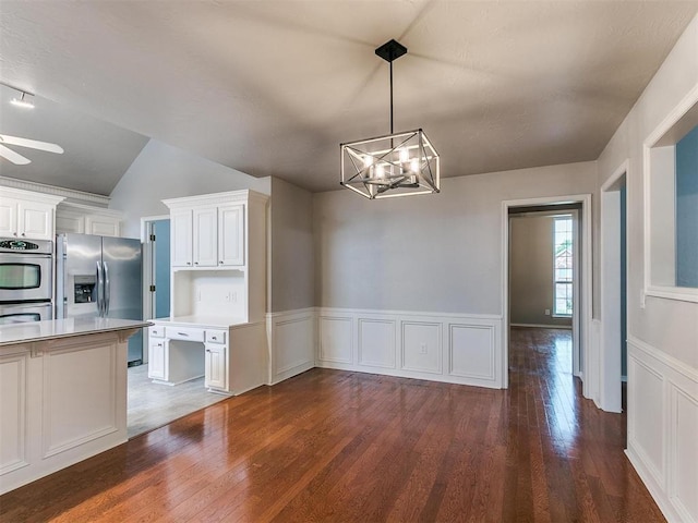 kitchen with dark wood-type flooring, white cabinetry, an inviting chandelier, hanging light fixtures, and stainless steel appliances