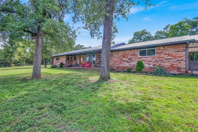 rear view of property featuring a lawn