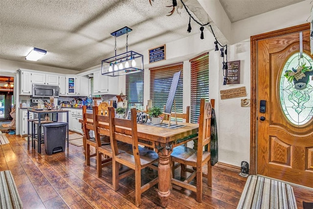 dining area featuring dark hardwood / wood-style floors and a textured ceiling