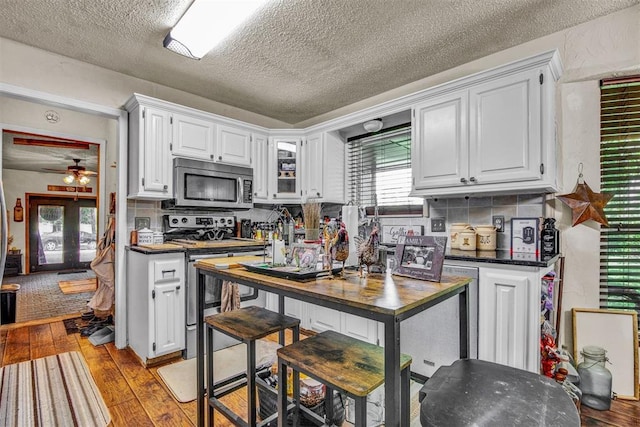 kitchen featuring white cabinets, appliances with stainless steel finishes, light hardwood / wood-style flooring, and french doors