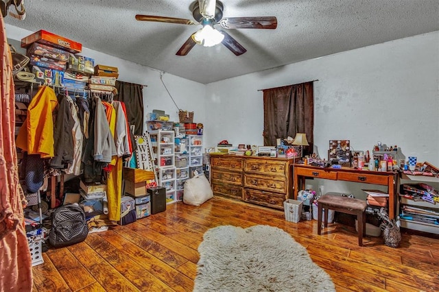 interior space featuring ceiling fan, a textured ceiling, and hardwood / wood-style flooring