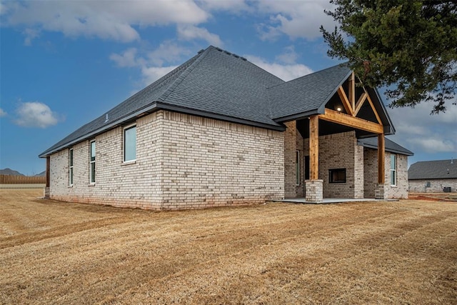 1127 Deer Rdg, Tuttle, OK 73089 - view of side of home with roof with shingles, brick siding, and a lawn