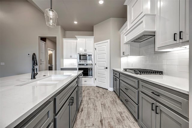 1127 Deer Rdg, Tuttle, OK 73089 - kitchen featuring appliances with stainless steel finishes, gray cabinets, pendant lighting, tasteful backsplash, and light stone counters