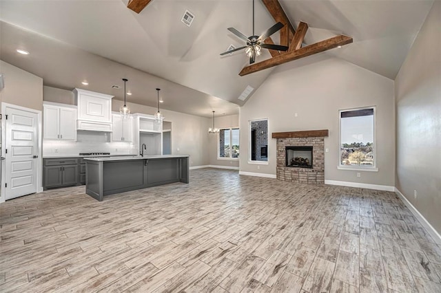 1127 Deer Rdg, Tuttle, OK 73089 - kitchen with open floor plan, high vaulted ceiling, beam ceiling, ceiling fan, and a kitchen island with sink