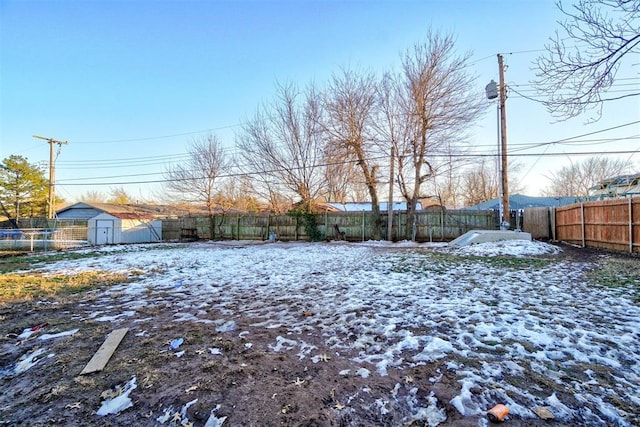 yard covered in snow with a shed