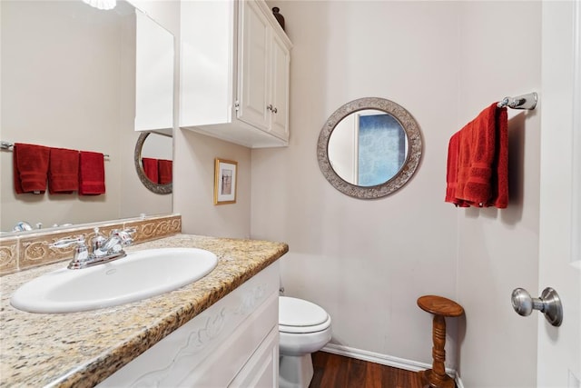 bathroom with hardwood / wood-style floors, vanity, and toilet