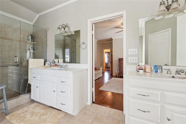 bathroom featuring ceiling fan, walk in shower, tile patterned floors, vanity, and ornamental molding