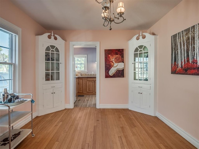 entryway featuring light hardwood / wood-style floors and a chandelier