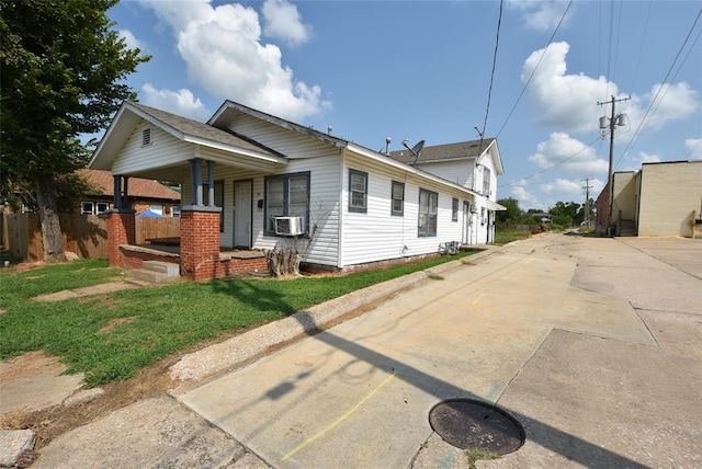 view of front of property featuring cooling unit, a front yard, and covered porch