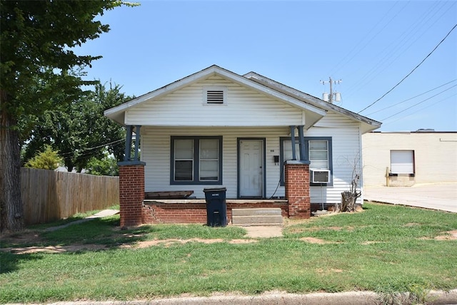 bungalow-style house with cooling unit, a porch, and a front lawn