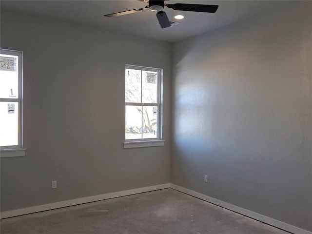 spare room featuring ceiling fan and concrete floors