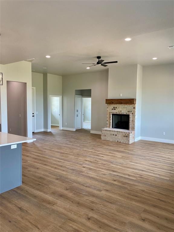 36120 Prairie Rdg, Shawnee, OK 74804 - unfurnished living room with a ceiling fan, recessed lighting, wood finished floors, and a brick fireplace