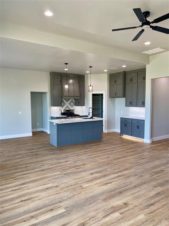 36120 Prairie Rdg, Shawnee, OK 74804 - kitchen featuring light wood finished floors, light countertops, a ceiling fan, pendant lighting, and recessed lighting