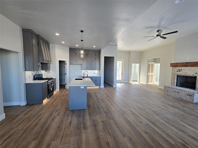 36120 Prairie Rdg, Shawnee, OK 74804 - kitchen with black gas range oven, open floor plan, a ceiling fan, dark wood-style flooring, and a center island with sink