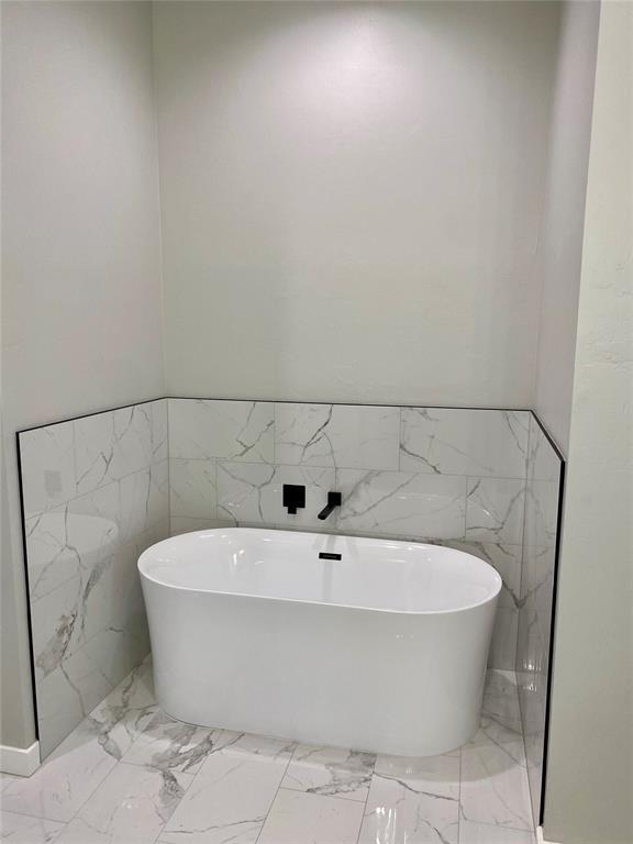 36120 Prairie Rdg, Shawnee, OK 74804 - full bathroom with marble finish flooring, a soaking tub, tile walls, and a wainscoted wall