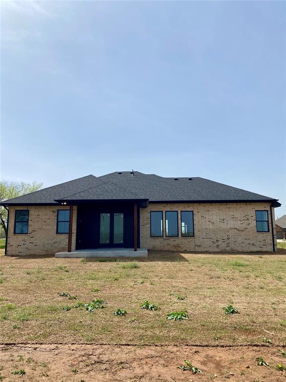 36120 Prairie Rdg, Shawnee, OK 74804 - back of property featuring brick siding, a lawn, a patio, and roof with shingles
