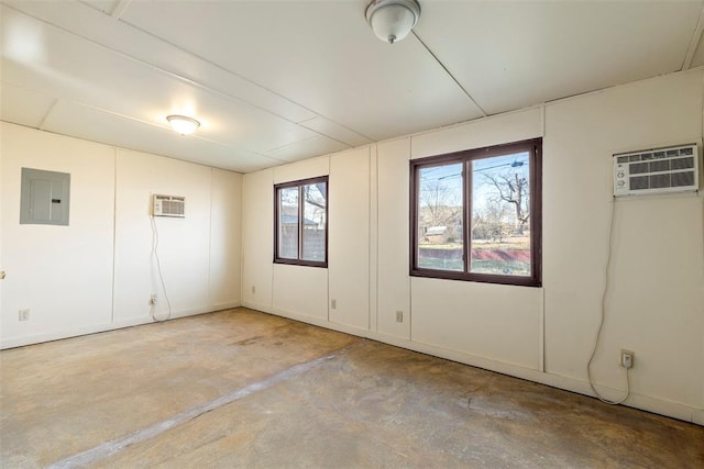 unfurnished room featuring electric panel, a wall unit AC, and concrete flooring