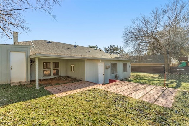 back of property with a lawn and a patio