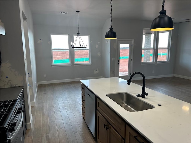 kitchen featuring wood finished floors, a sink, visible vents, and pendant lighting