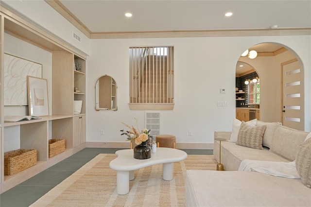 living room featuring dark tile patterned flooring, ornamental molding, and built in features