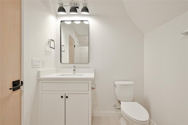 bathroom featuring vaulted ceiling, vanity, and toilet