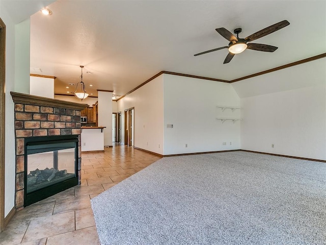 tiled living room with ceiling fan, ornamental molding, lofted ceiling, and a fireplace