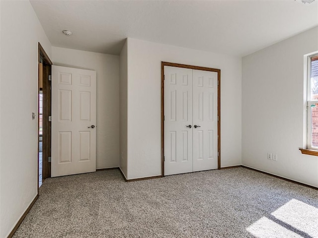 unfurnished bedroom with a closet and light carpet