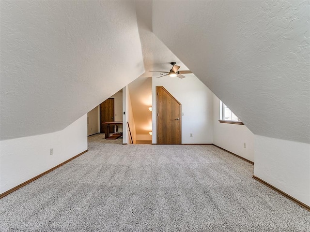 additional living space featuring vaulted ceiling, carpet floors, ceiling fan, and a textured ceiling