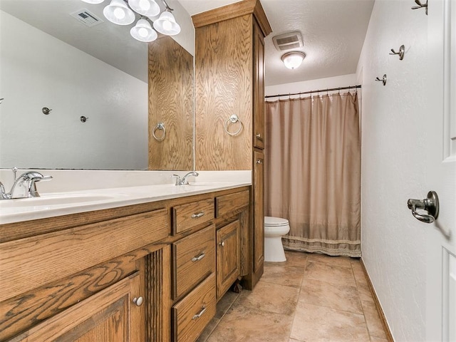 bathroom with toilet, vanity, and a textured ceiling