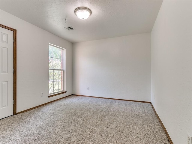 carpeted spare room featuring a textured ceiling