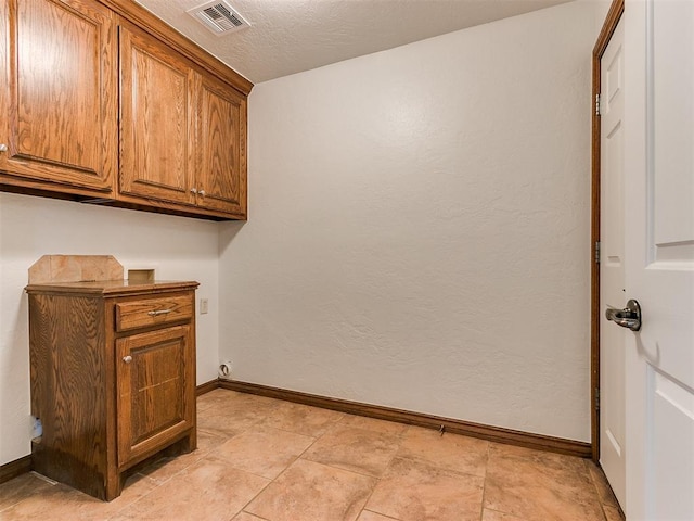 washroom featuring a textured ceiling, cabinets, and hookup for a washing machine