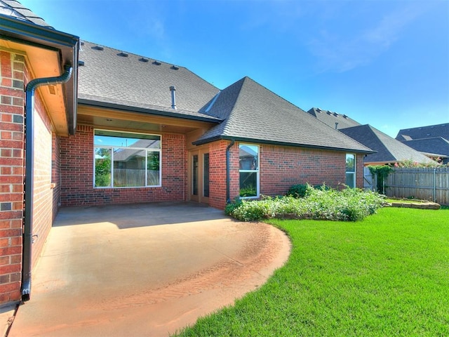 back of house with a patio area and a lawn