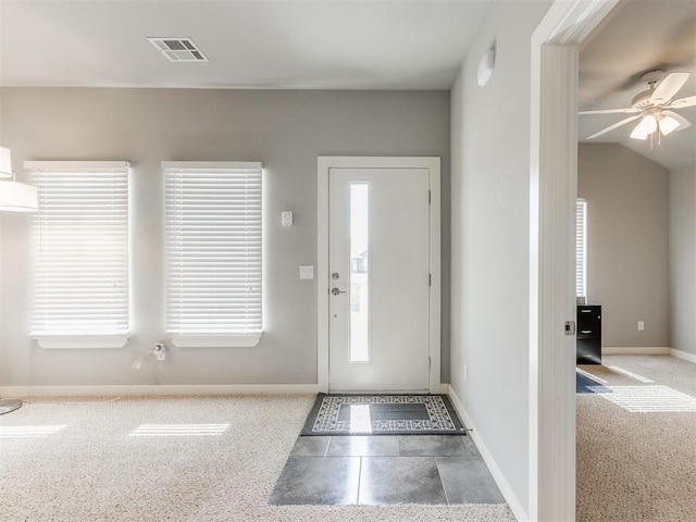 entrance foyer with ceiling fan, vaulted ceiling, and carpet floors